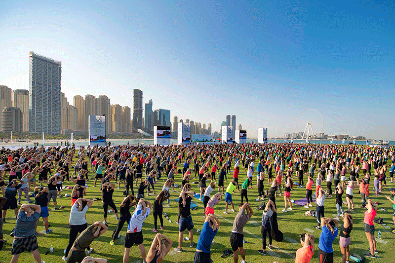Participants practicing yoga under the Dubai Frame during Dubai Fitness Challenge 2025