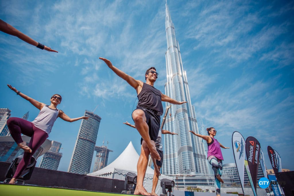Participants practicing yoga under the Dubai Frame during Dubai Fitness Challenge 2025