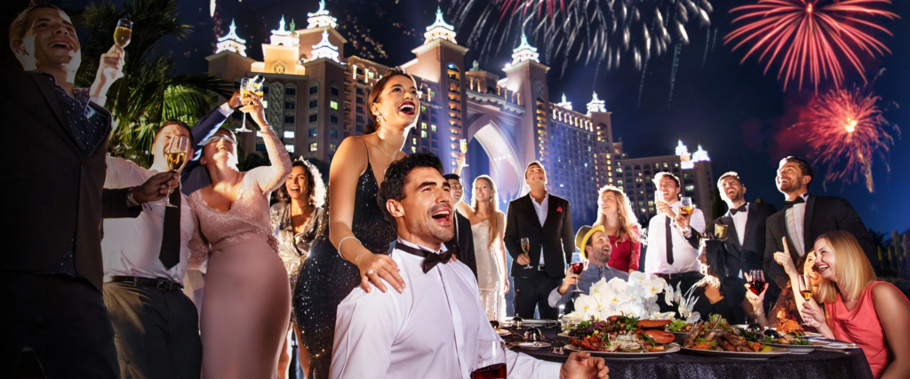 Crowds watching Burj Khalifa lit by fireworks over Downtown Dubai at night