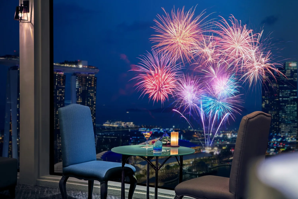 Crowds watching Burj Khalifa lit by fireworks over Downtown Dubai at night