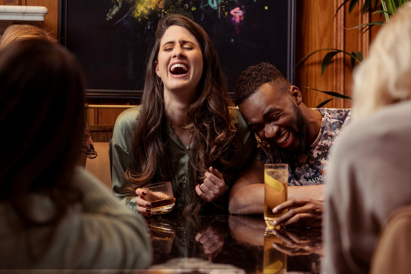 Friends laughing together over drinks at a Dubai brunch